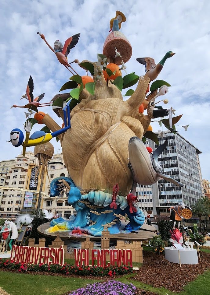 Photo of a large sculpture with fantastical flying figures and a whale.